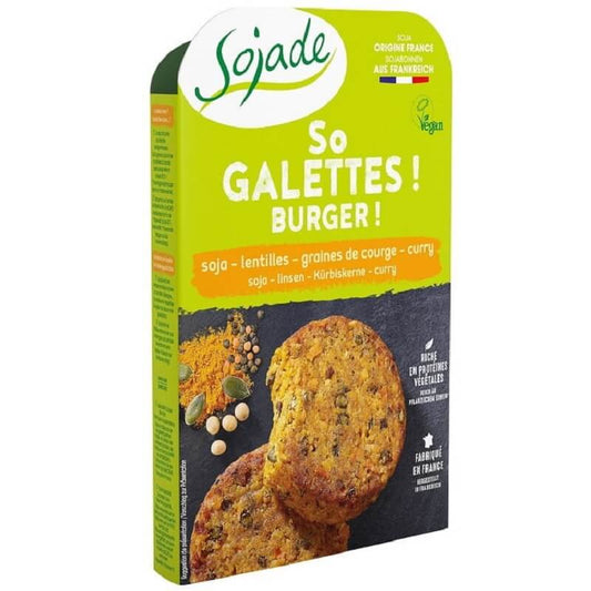 Burger mit Sojalinsen, Kürbiskernen und Curry, BIO, 180 g, von SOJADE, auf einem Teller mit frischen Zutaten.
