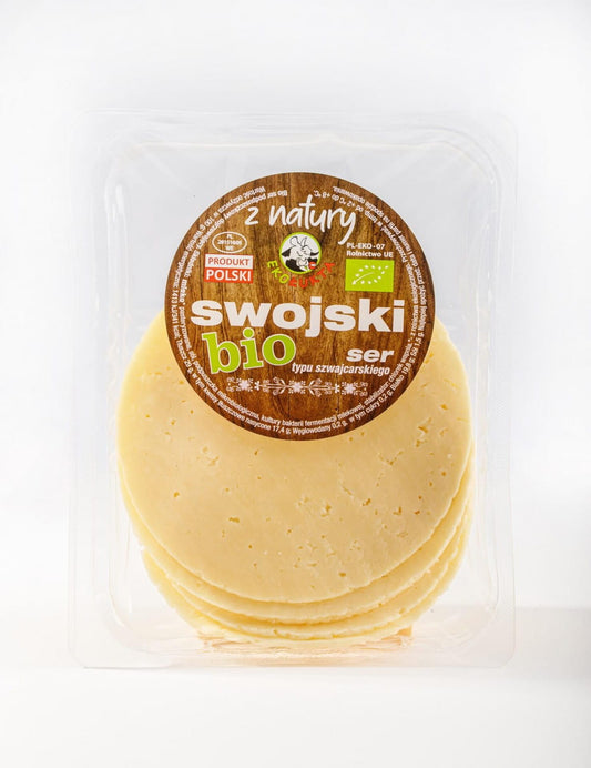 Hausgemachte Bio-Käsescheiben von EKO ŁUKTA, 100 g, frische, natürliche Käsescheiben auf einem Holzbrett.